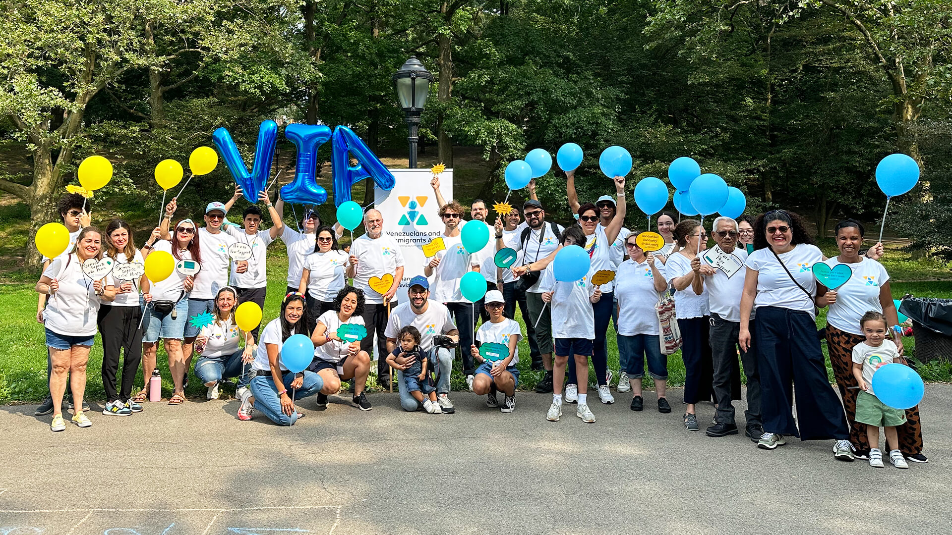 Group of VIA volunteers posing for a photo on a sidewalk in a park.