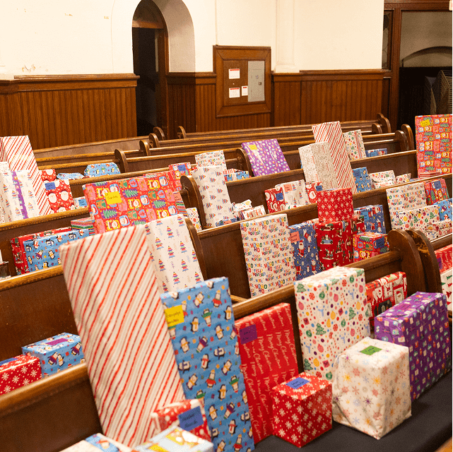 Rows of wrapped Christmas presents arranged for distribution at VIA’s Annual Toy Drive.