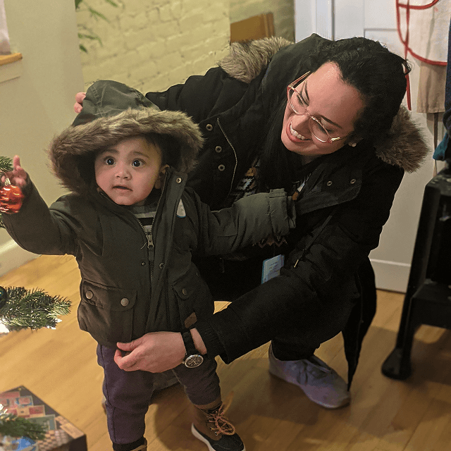 Volunteer helping a young child try on a new winter coat during VIA’s Annual Winter Coat Drive.